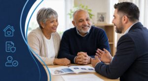 Equity Release Adviser in Upminster meeting an older couple in a bright office, discussing later life lending options with paperwork on the desk.