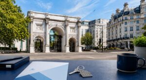 Mortgage Broker in Marble Arch with property keys and blue mortgage documents overlooking the Marble Arch landmark in London.