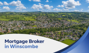 A promotional banner showing an aerial view of Winscombe surrounded by green countryside on a bright summer’s day, beneath a blue sky with realistic white clouds. A curved white panel and blue swoosh design frame the bottom of the image, with the title “Mortgage Broker in Winscombe” in two shades of blue.