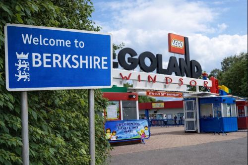 “Welcome to Berkshire road sign beside the entrance to Legoland Windsor on a bright day.”