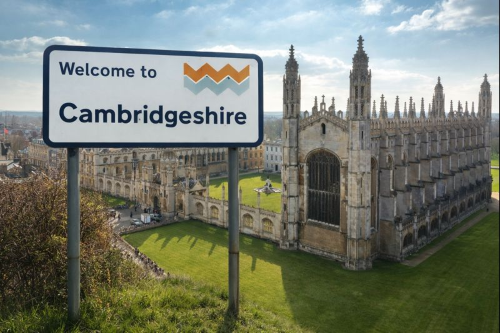 “Welcome to Cambridgeshire sign blended with an aerial view of King’s College Chapel and historic Cambridge buildings.”