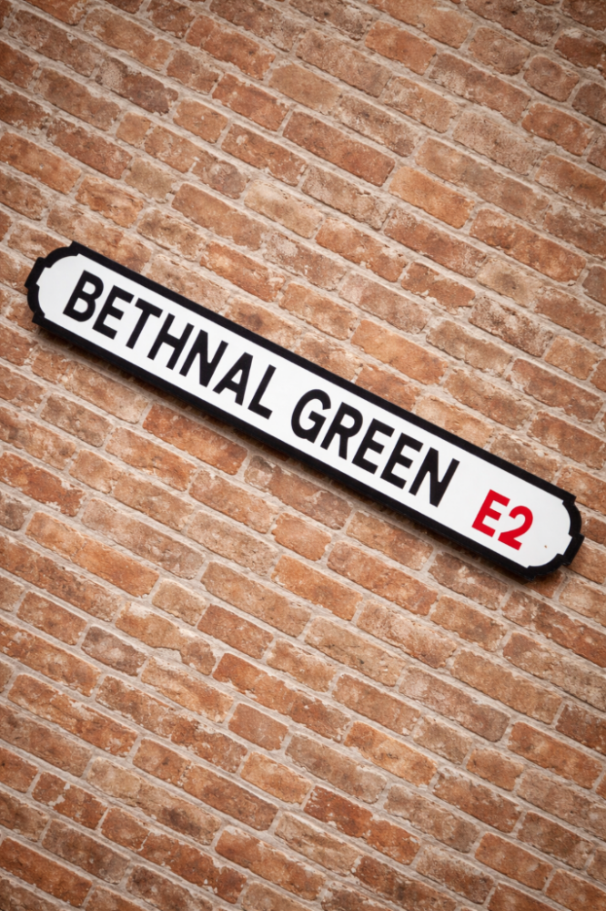 Street sign reading “Bethnal Green E2” mounted diagonally on a red brick wall. Bootstrap Finance mortgage broker in Bethnal Green E2