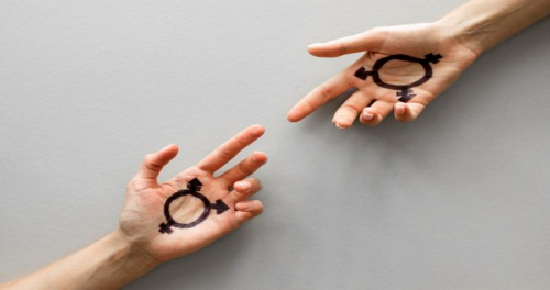 Two outstretched hands facing each other against a grey background, each palm marked with a black gender symbol combining male, female, and transgender elements.