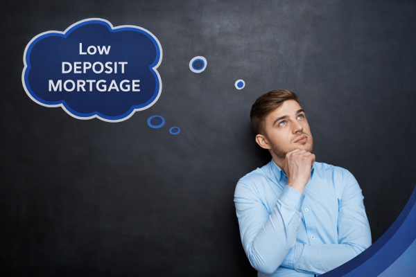 Man in a light blue shirt standing against a dark chalkboard background, looking up thoughtfully with his hand on his chin. A blue branded thought bubble beside him reads “Low Deposit Mortgage,” with curved blue design elements in the corner.