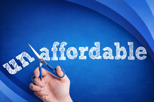 Graphic showing the word “unaffordable” in white chalk style text on a blue branded background with layered curved rings. A hand holding blue handled scissors is cutting through the “un” prefix to suggest the word “affordable.”