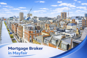 Bright summer rooftop view over Mayfair featuring traditional red brick buildings and modern developments under a clear blue sky, with a white and blue curved banner at the bottom displaying the text “Mortgage Broker in Mayfair”.