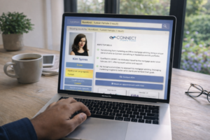 Person using a laptop at a wooden table, searching online for a Turkish mortgage broker in Romford, Essex with a broker profile displayed on the screen showing location in Essex, Turkish as an additional language, qualifications, and contact options, set against a bright home background with a coffee cup nearby.