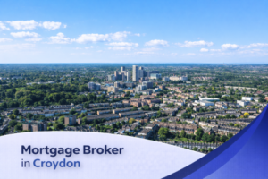 Bright aerial view of Croydon on a clear summer day, showing a mix of modern high-rise buildings, residential streets, and surrounding greenery under a blue sky with soft, realistic clouds, with a clean curved banner at the bottom displaying the text “Mortgage Broker in Croydon”.