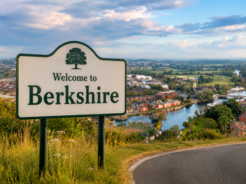 Welcome to Berkshire road sign overlooking a riverside town, green countryside, local roads and the River Thames under a cloudy blue sky. Why Move to Berkshire